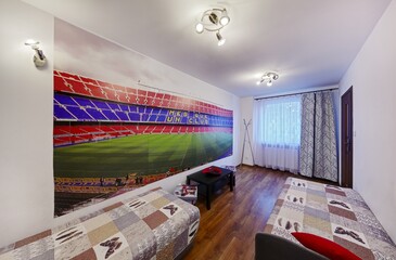 Pokój z sypialnia i sportową fototapetą na ścianie