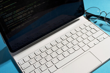 a minimalistic workplace for a designer or developer. A laptop with a program code on the screen...