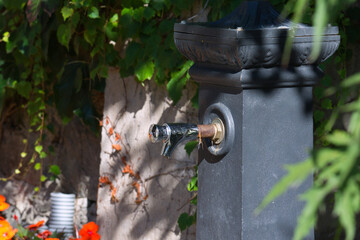 Eine graue Säule mit einem Trinkwasserspender in einem Park