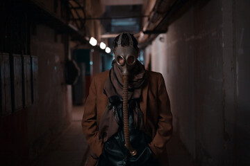 A post-apocalyptic concept. A woman in a gas mask escapes from chemical contamination or a...