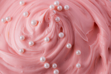 Pink icing frosting with small pearl sprinkles close up texture