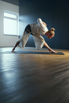 Yogi man doing pyramid pose, parshvottanasana. Yoga practice in the studio.