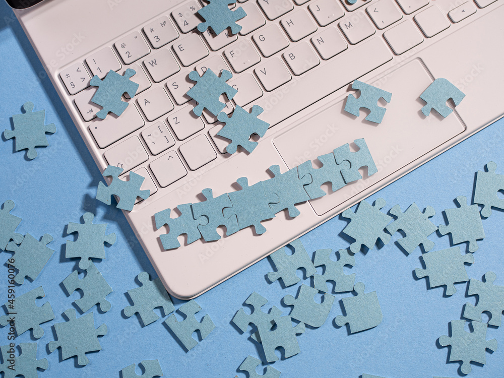 Poster puzzle elements on a laptop keyboard, software development, concept. mosaic on a blue background