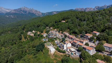 Fototapeta na wymiar Aerial view of the mountainous village of Zonza in the South of Corsica, France, with the Peaks of Bavella in the background