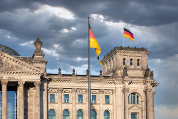 Fototapeta na wymiar Facade Reichstag building Berlin with german flag and threatening air