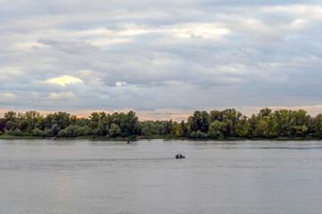 The harsh Dnieper river, autumn landscape, a boat with fishermen