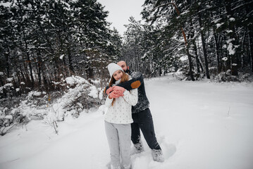 Couple playing with snow in the forest