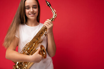 Closeup shot of pretty positive happy smiling brunet little girl wearing white t-shirt for mockup...