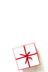Gift white box with red ribbon and bow isolated on white. View from above.