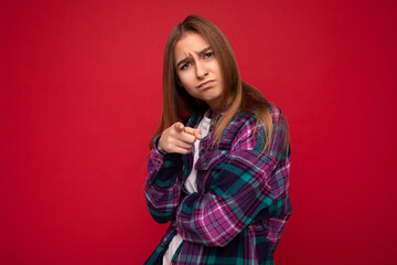 Photo of resentful sorrowful offended young charming nice pretty dark blonde lady with sincere emotions wearing hipster purple check shirt isolated over red background with free space