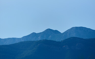 Fototapeta na wymiar Blue mountain peaks against the blue sky in the morning