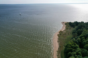 Aerial view with dunes, forest, sea and sail boat in Curonian spit on a sunny day photographed with...