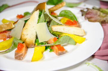 salad with salmon and red caviar and white breadcrumbs with red caviar on a white plate 