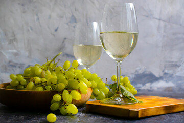 glass of white wine grapes on a concrete background