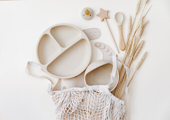 Flat lay beige silicone dishware for baby. Serving kid first feeding concept. copy space, top view