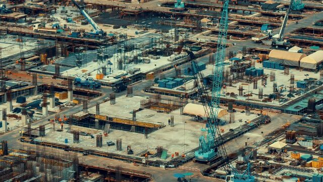 Time lapse of construction site with heavy construction machinery in metropolis captured during the early stage of mega construction project .