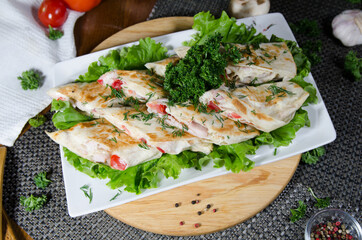 chicken with tomato and cream sauce in pita bread on a white plate decorated with greens, a light healthy snack, a healthy snack, a light meal
