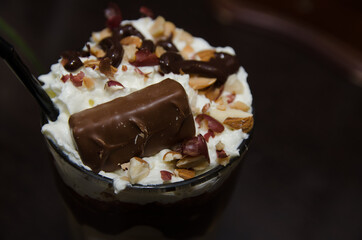 chocolate milkshake with whipped cream sprinkled with nuts and a piece of chocolate
