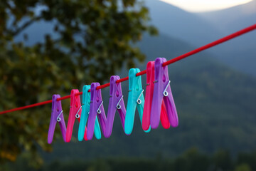 Colorful clothespins hanging on washing line outdoors
