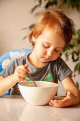 Portrait of beautiful little child girl eats breakfast.