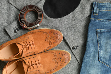 A pair of brown suede derby shoes and jeans on tweed blazer background. Top view.