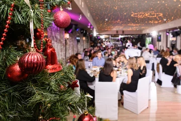 Close up of decorated christmas tree in the restaurant. New Year's corporate event of a large company. Blurred background, selective focus. © spritnyuk
