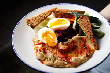 Hummus plate with boiled egg and rye bread