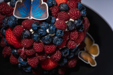 top view of cake with berries, blueberries, strawberries on a light background, close up view. Summer berry cake concept