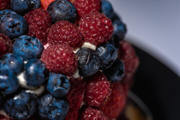 top view of cake with berries, blueberries, strawberries on a light background, close up view. Summer berry cake concept