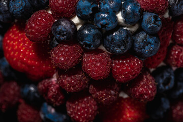 top view of cake with berries, blueberries, strawberries on a light background, close up view. Summer berry cake concept