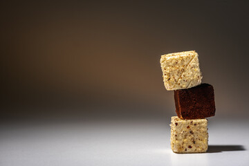 Pieces of white and chocolate chip cookies arranged on top of each other, like a pyramid, on a light background. Sweet concept