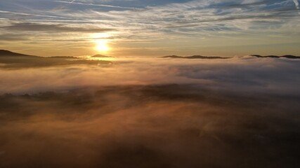 Fototapeta na wymiar Rolling fog clouds during a morning sunrise
