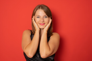 Naklejka premium Close up portrait of smiling young woman in black dress. Christmas celebration concept.