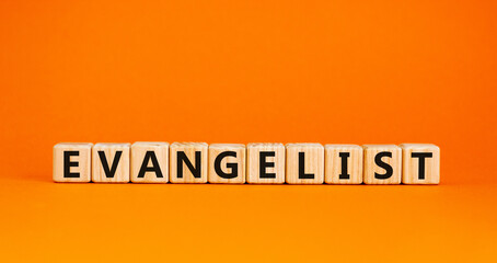 Evangelist symbol. The word Evangelist on wooden cubes. Beautiful orange table, orange background. Business and evangelist concept. Copy space. - obrazy, fototapety, plakaty