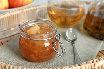 Obraz na płótnie Canvas Delicious apple jam in jar on tray, closeup