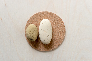 two brick stones on a cork coaster on a wooden background