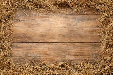 Frame made of dried hay on wooden background, top view. Space for text