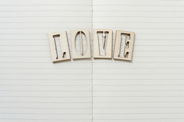 paper with the word "love" written in wooden stencil font