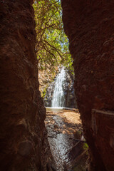 Waterfall seen through a broken boulder