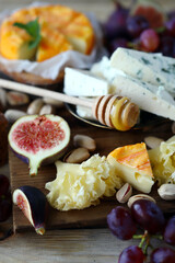 Gourmet cheese board with fruits and nuts. Keto snacks.