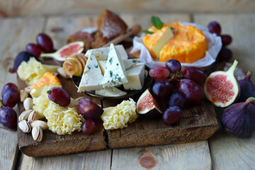 Gourmet cheese board with fruits and nuts. Keto snacks.