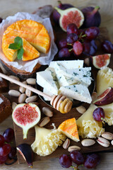 Gourmet cheese board with fruits and nuts. Keto snacks.