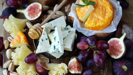 Gourmet cheese board with fruits and nuts. Keto snacks.