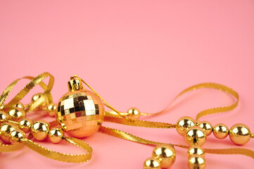Golden beads on pink background copy space