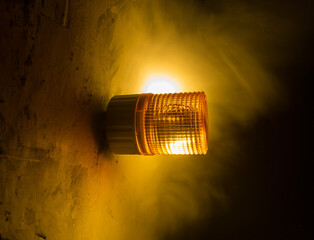 Emergency lighting in the factory, Warning light, Orange siren on concrete wall.