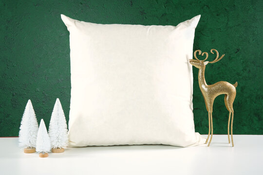 Throw pillow cushion product mockup. Christmas svg craft product mockup with gold reindeer and white Xmas trees against a textured green background.