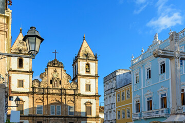 Facade of an old historic church and colorful colonial-style houses in the central square of the Pelourinho district in Salvador city, Bahia