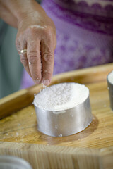 woman adding salt to artisan soft goat cheese