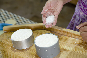 woman adding salt to artisan soft goat cheese