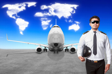 Airplane Captain in front of movable boarding ramp near the entrance to the passenger airplane with clouds in shape of world map concept for transportation around the world
